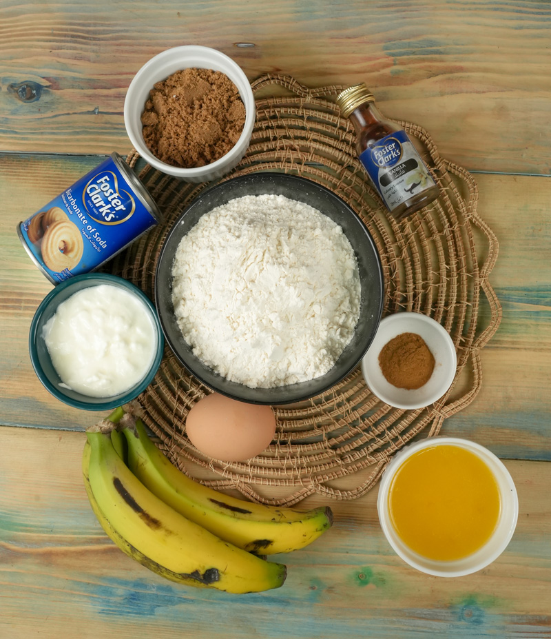 Ingredients for homemade mini banana muffins on wooden table