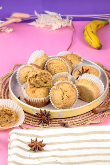 Mini banana muffins with ripe banana and spices on woven placemat