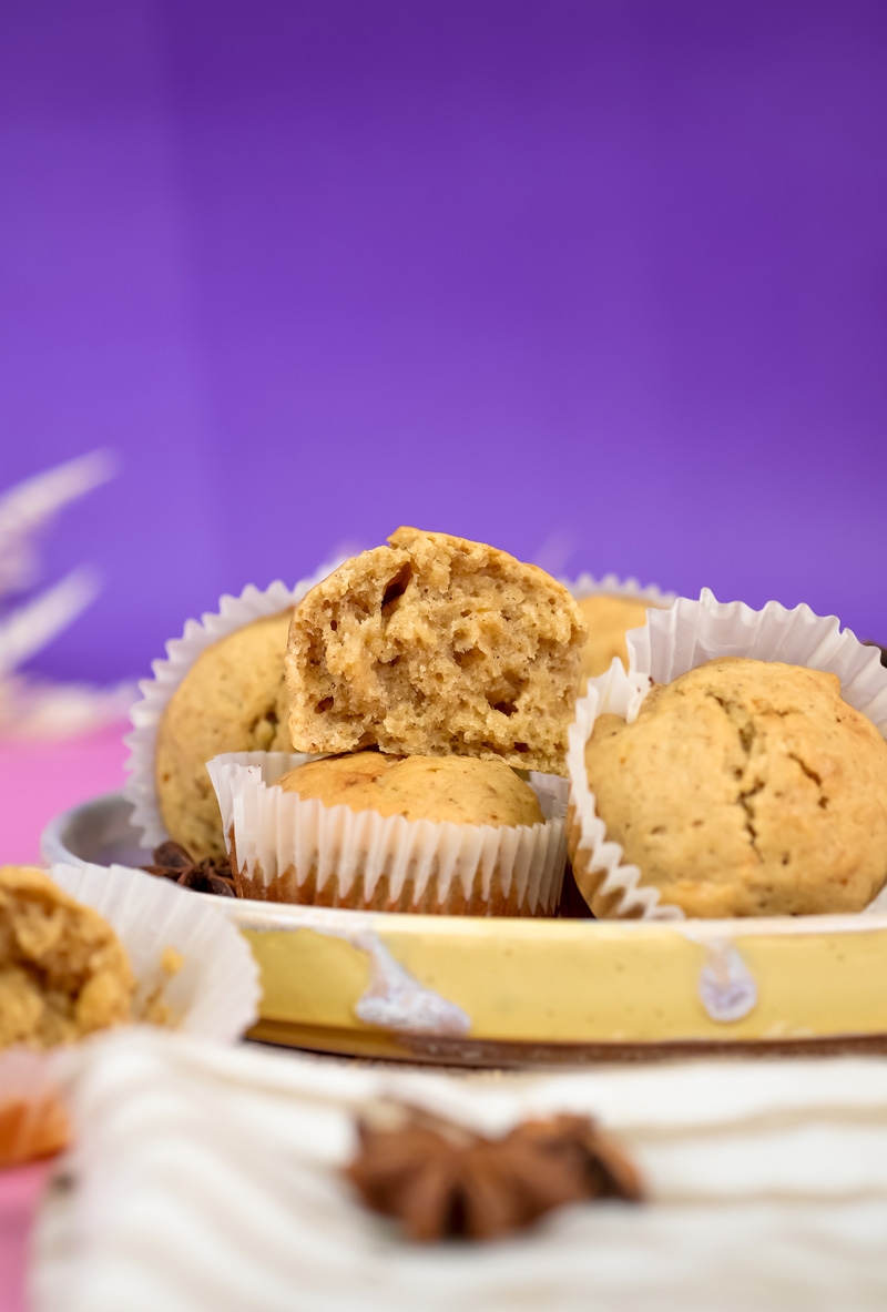 Mini banana muffins with visible crumb texture against purple backdrop
