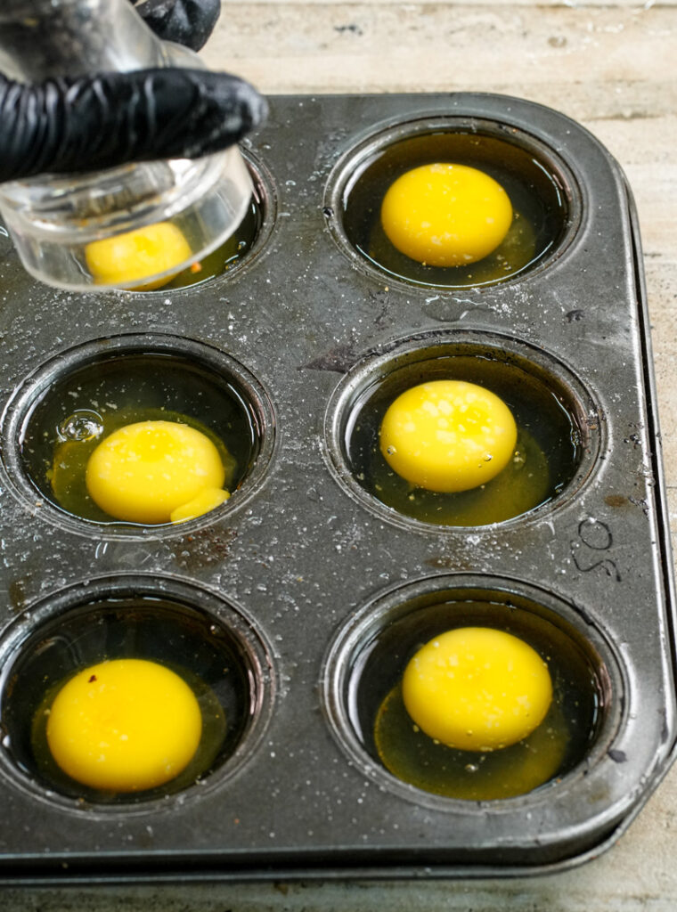 Seasoning eggs in muffin tin before baking