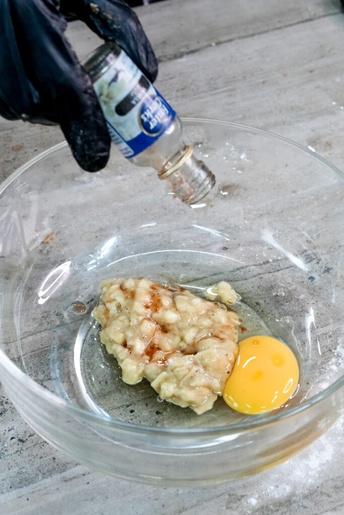 Adding egg to mashed banana for chocolate chip muffins