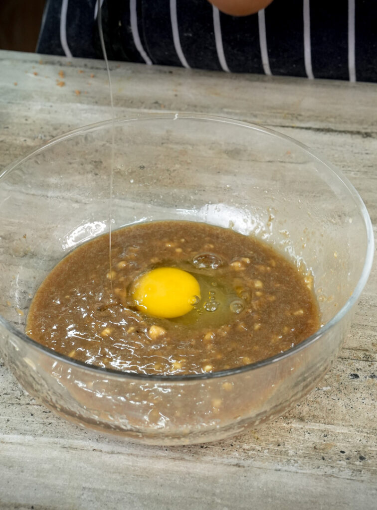 Adding fresh egg to banana muffin mixture