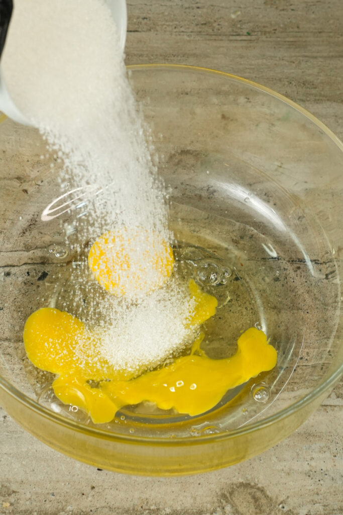 Adding sugar to eggs for chocolate muffin recipe
