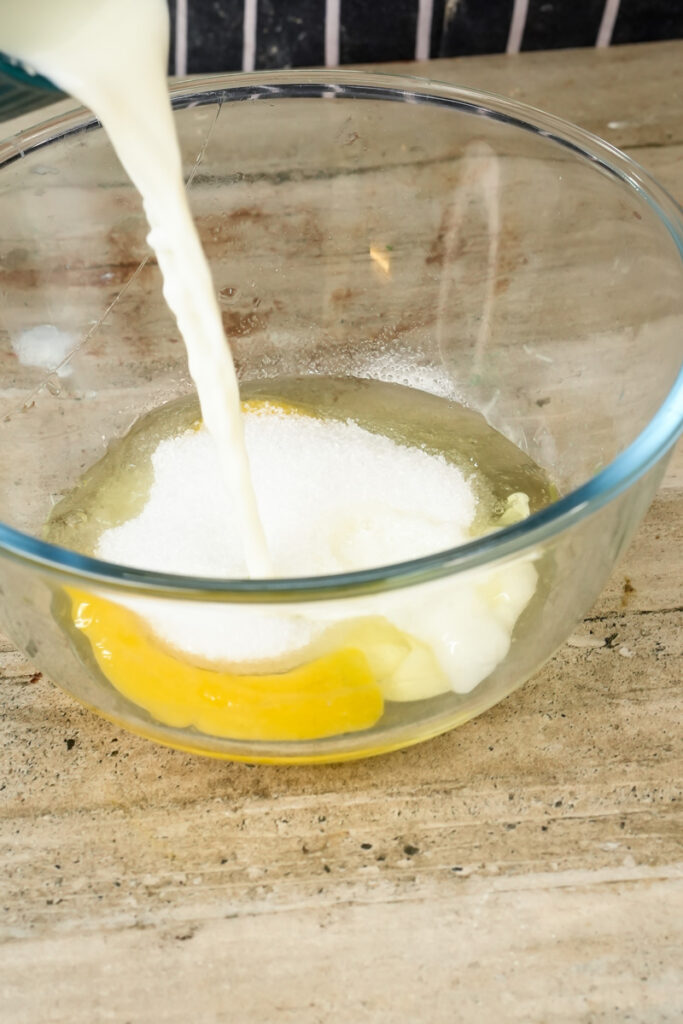 Pouring milk into egg mixture for pistachio muffins