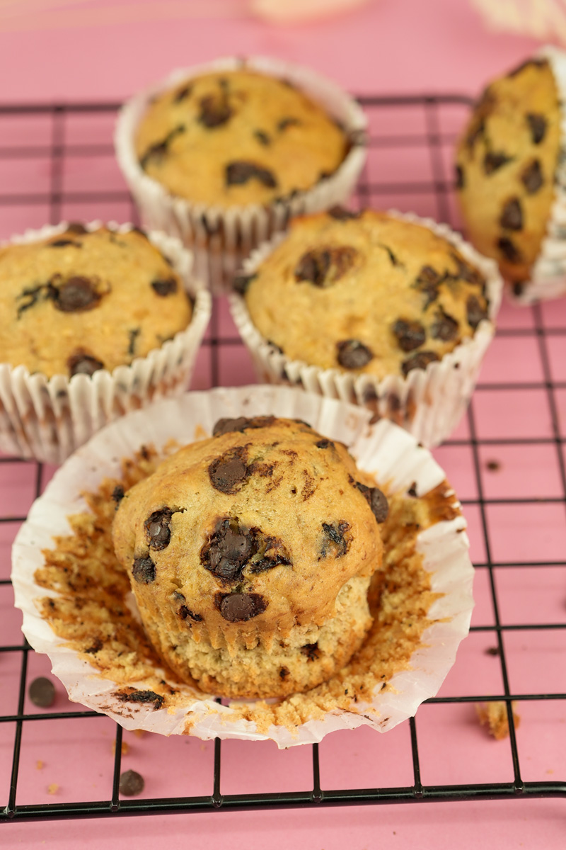 Banana chocolate chip muffin with paper liner partially removed