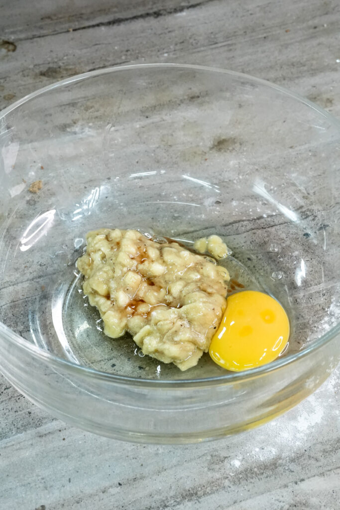 Banana and egg mixture in glass bowl for muffin batter
