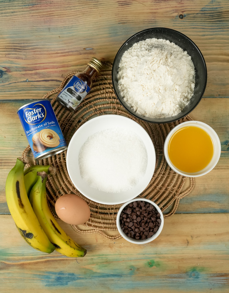 Banana chocolate chip muffin ingredients on wooden surface