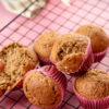 Banana muffins with one split open showing interior crumb