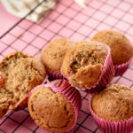 Banana muffins with one split open showing interior crumb