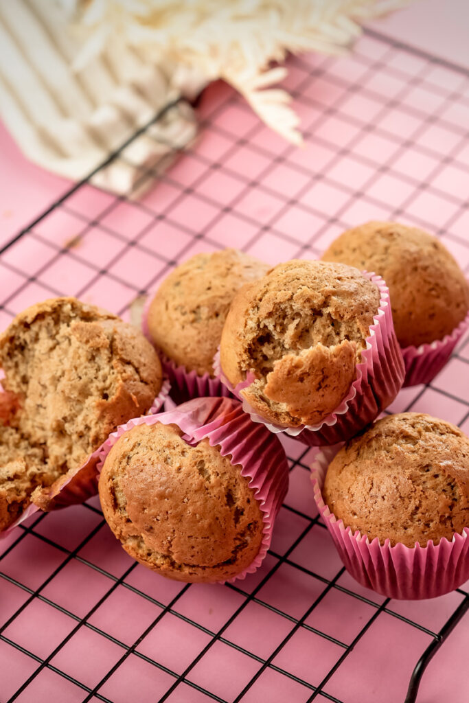 Banana muffins with one split open showing interior crumb