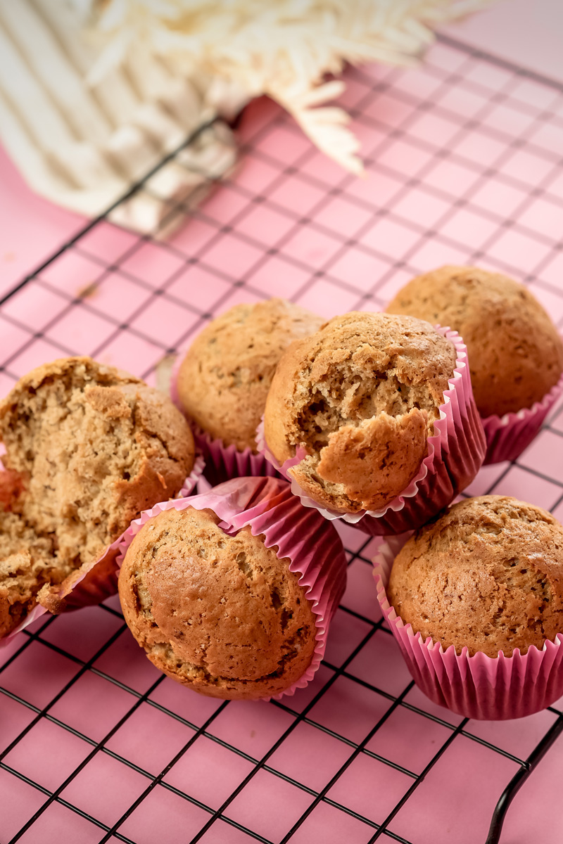 Banana muffins with one split open showing interior crumb