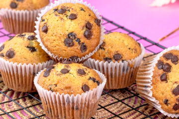 Batch of banana protein chocolate chip muffins cooling on a wire rack.