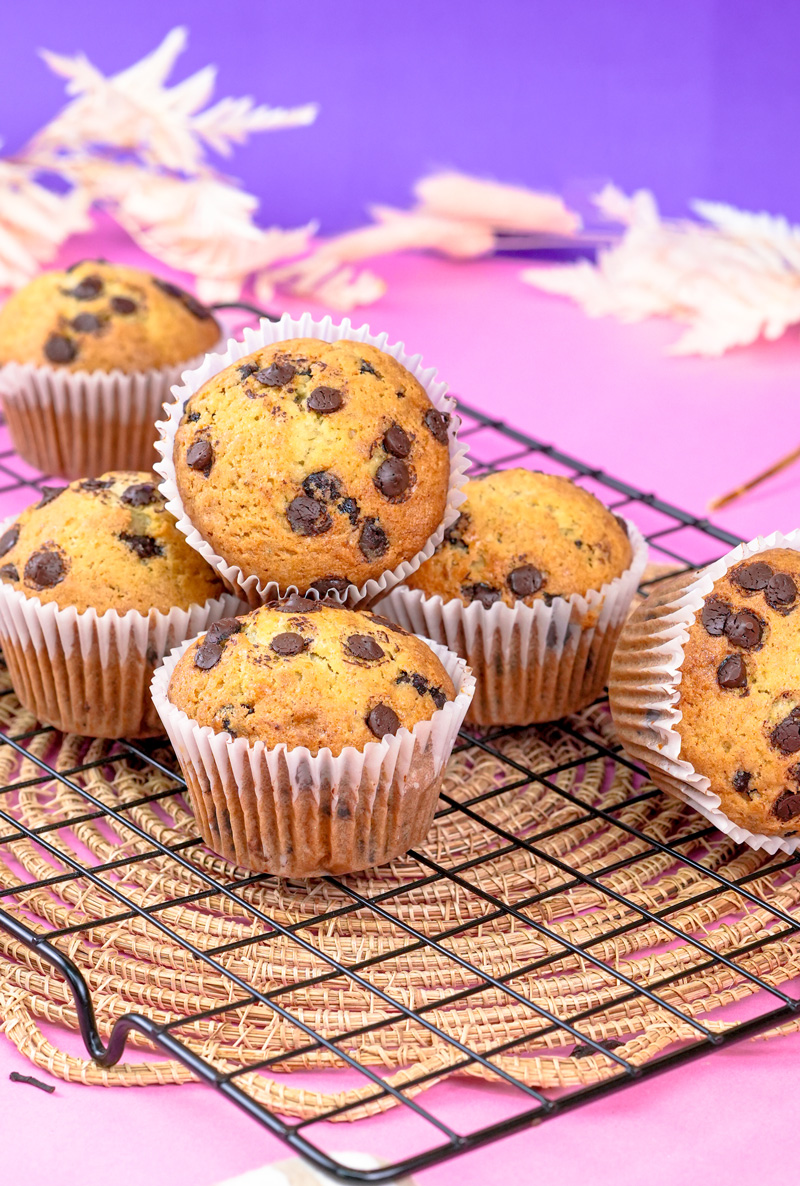 Batch of banana protein chocolate chip muffins cooling on a wire rack.