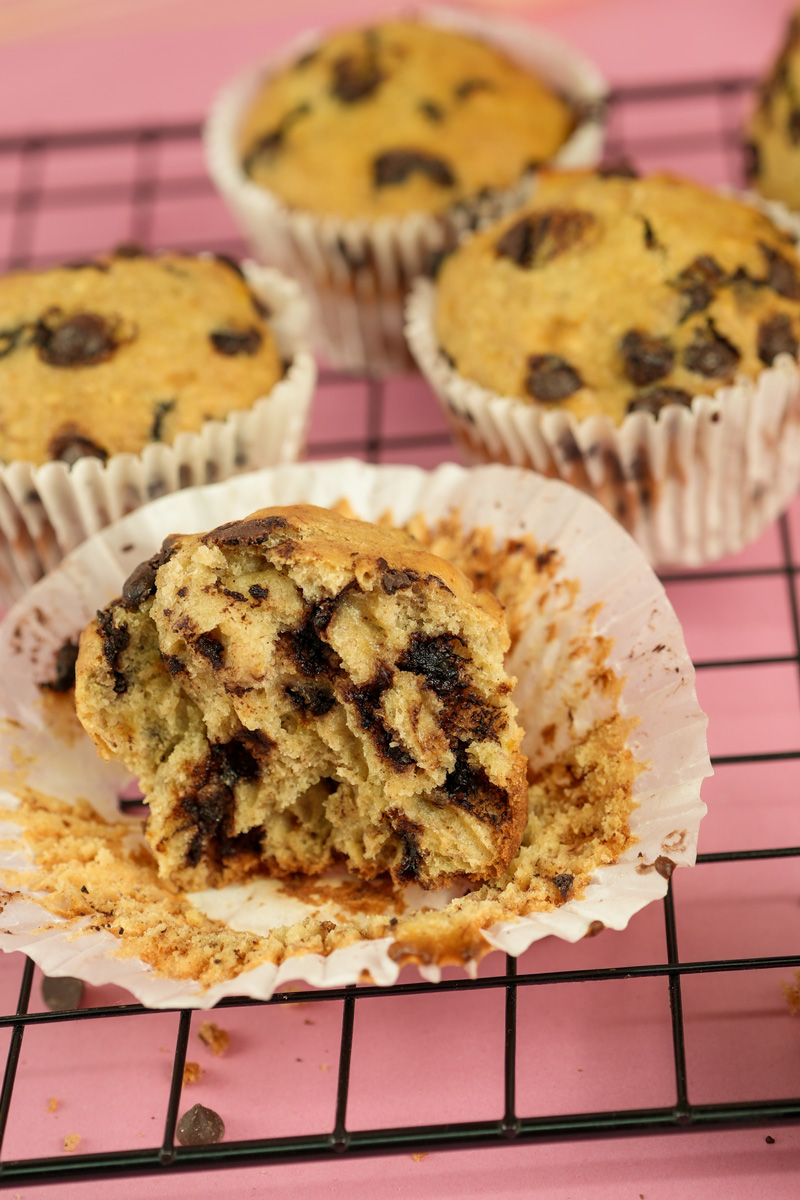 Bite taken from banana chocolate chip muffin showing soft interior texture