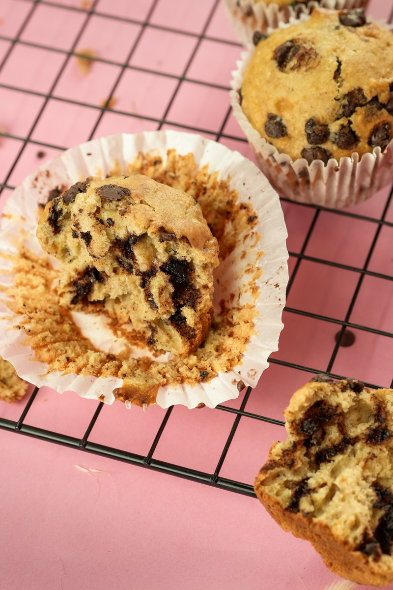 Broken banana chocolate chip muffin revealing moist crumb and melted chips