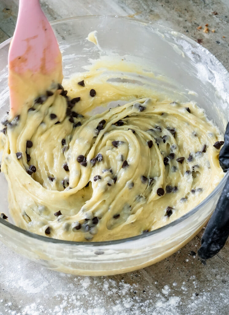 Mixing banana chocolate chip muffin batter with wooden spatula