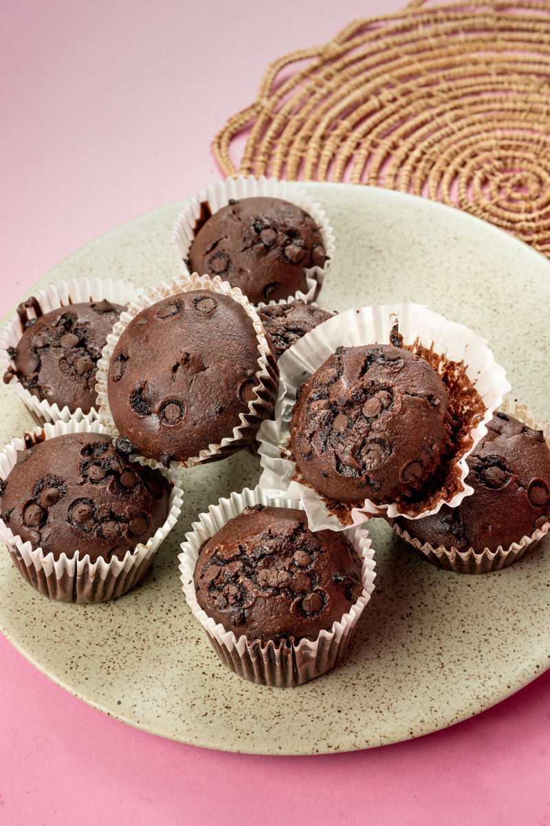 Double chocolate muffins with visible chocolate chips on ceramic plate