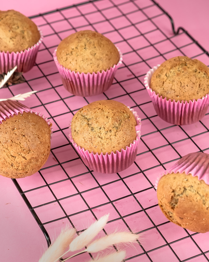 Banana muffins with pink cupcake liners on wire rack
