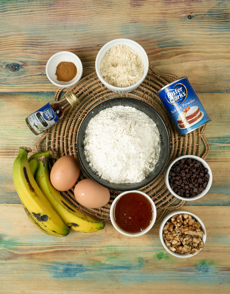 Ingredients for banana protein muffins: bananas, eggs, flour, chocolate chips, walnuts, baking powder, vanilla, cinnamon.