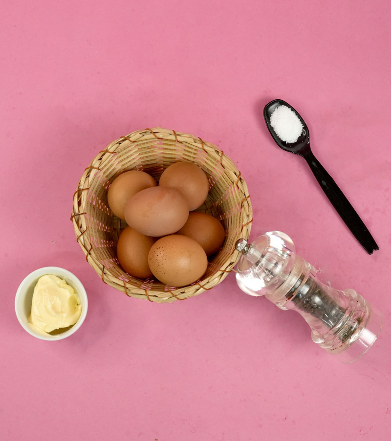 Ingredients for muffin tin baked eggs on pink background