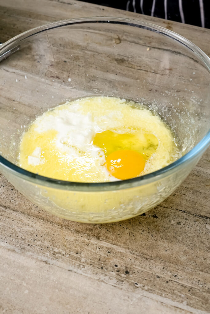 Adding eggs to the coffee cake muffin mixture.