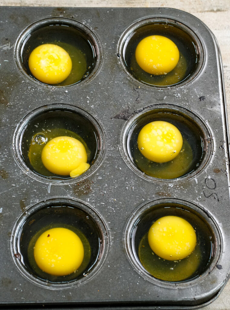 Muffin tin filled with fresh egg yolks