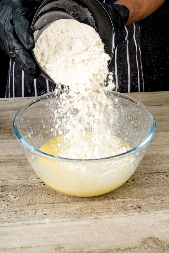 Adding flour to the coffee cake muffin batter.