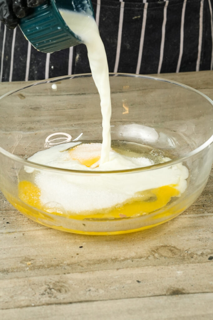 Pouring milk into chocolate muffin wet ingredients