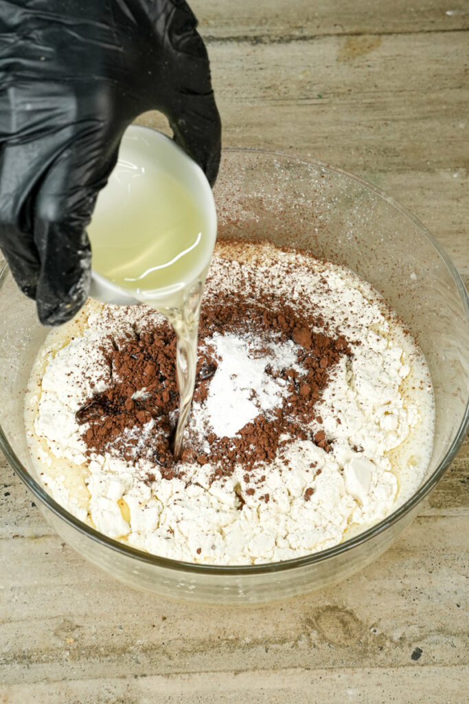 Pouring oil into chocolate muffin dry ingredients