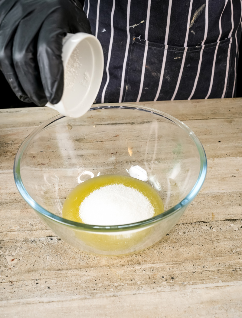 Adding sugar to the wet ingredients for coffee cake muffins.