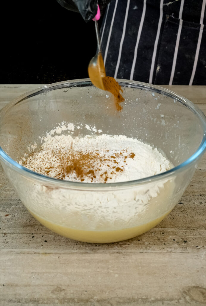 Sprinkling cinnamon into oatmeal muffin batter
