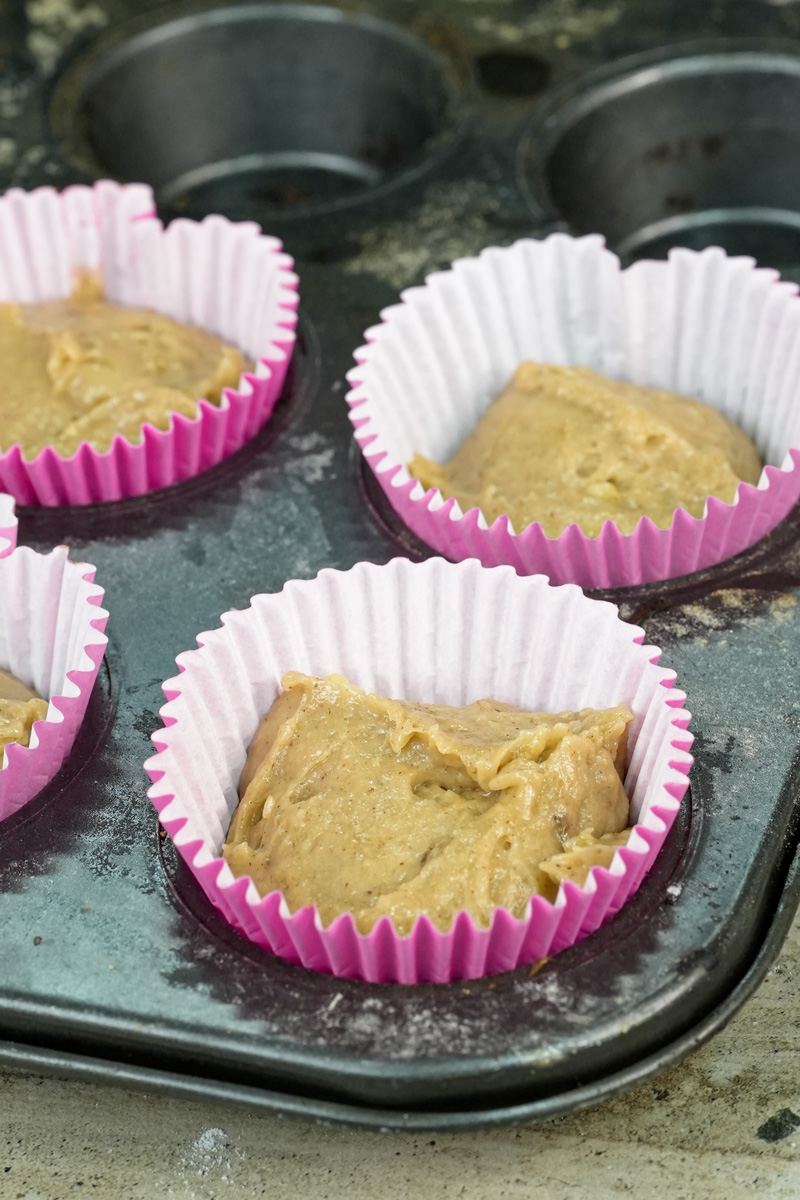 Unbaked banana muffin batter in pink liners ready for oven