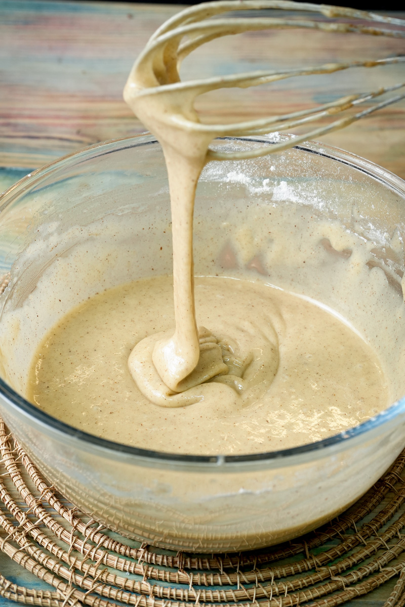 Whisking cinnamon muffin batter in a glass bowl until smooth
