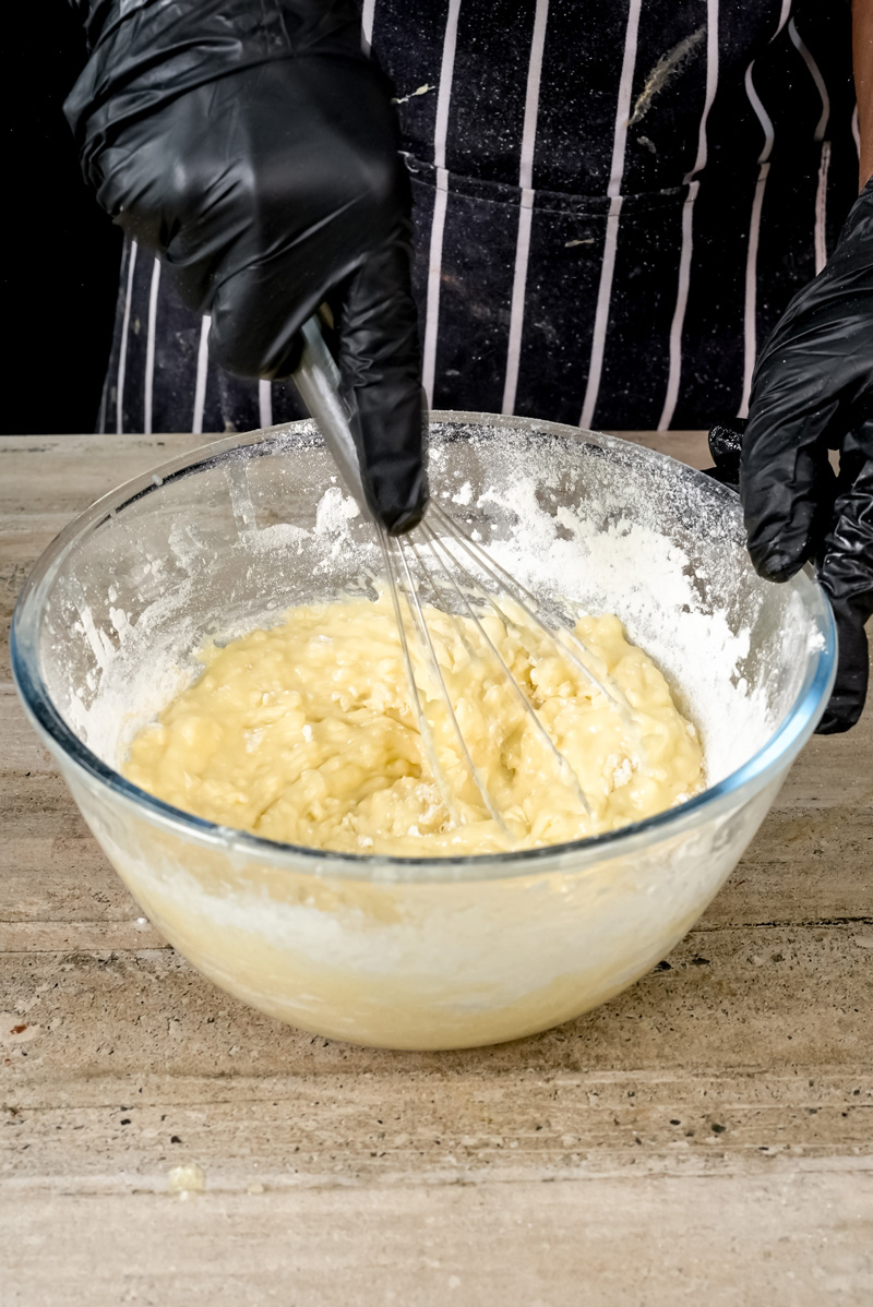 Mixing coffee cake muffin batter with a whisk.