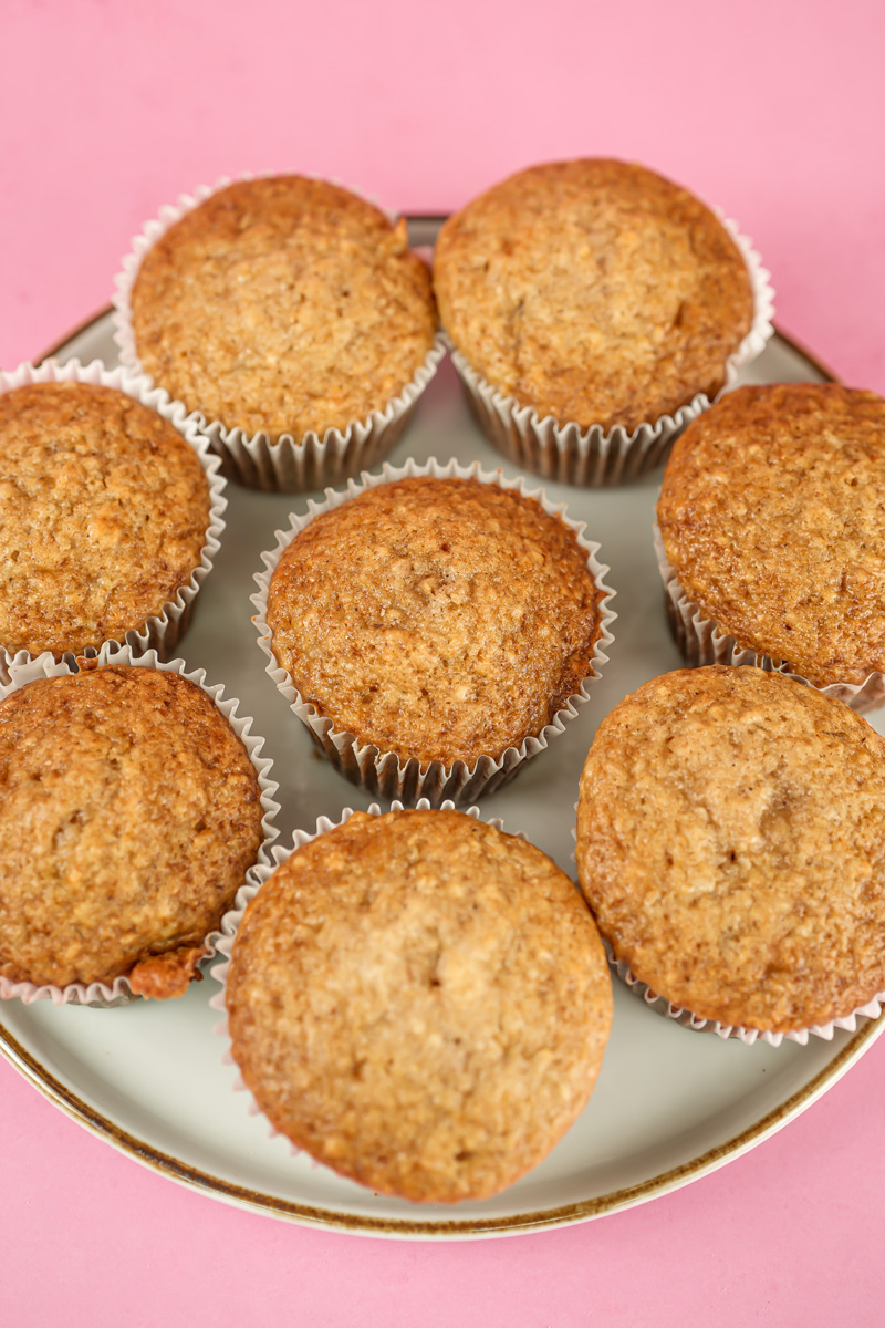 Freshly baked applesauce muffins on white plate