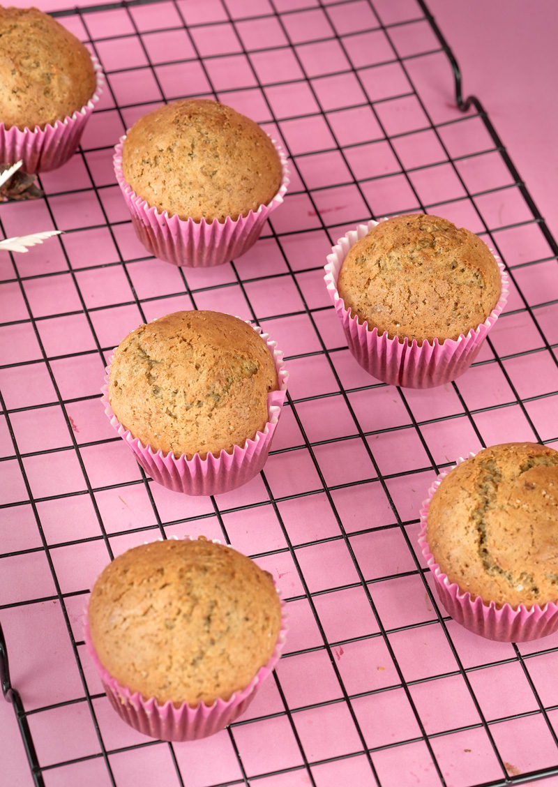 Golden banana muffins in pink liners with dried flowers