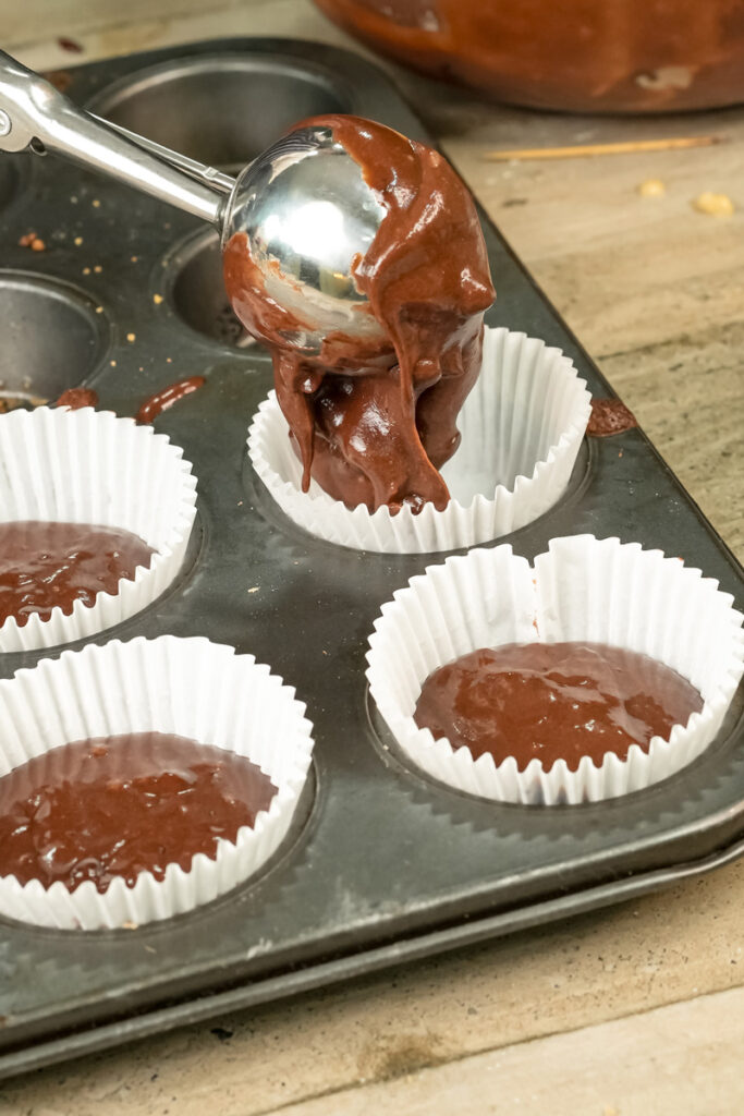 Portioning double chocolate muffin batter with ice cream scoop