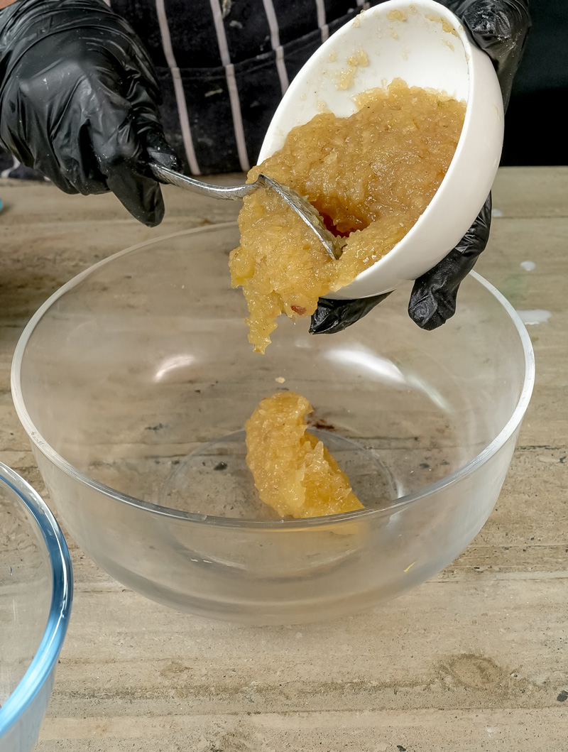 Scooping homemade applesauce for applesauce muffin recipe
