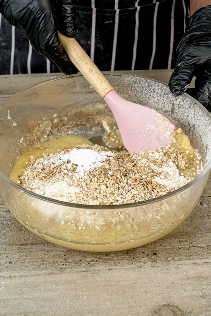 Mixing applesauce muffin batter with pink spatula
