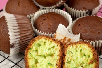 Pistachio muffins with one cut open on wire rack