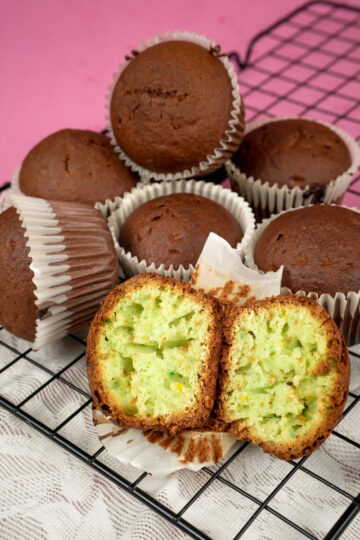 Pistachio muffins with one cut open on wire rack