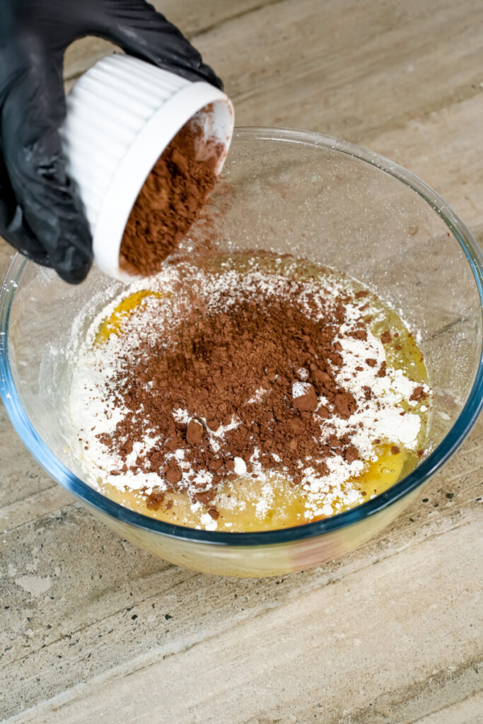 Adding cocoa powder to chocolate muffin batter
