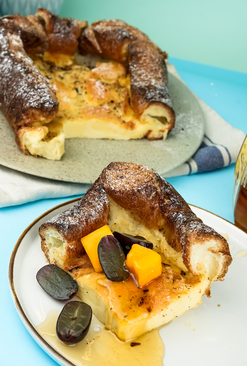 Baked German pancakes served on plates with fruit toppings