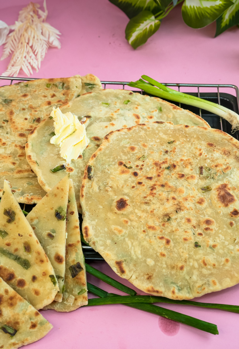 Stack of cooked Chinese scallion pancakes on cooling rack