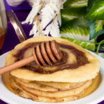 Final presentation of cinnamon roll pancakes with honey and decorative honey dipper