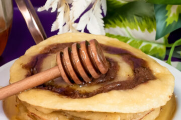 Final presentation of cinnamon roll pancakes with honey and decorative honey dipper