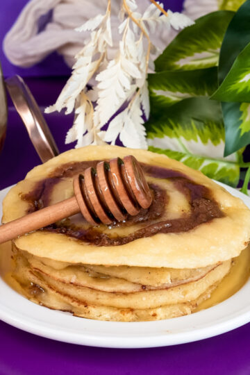 Final presentation of cinnamon roll pancakes with honey and decorative honey dipper
