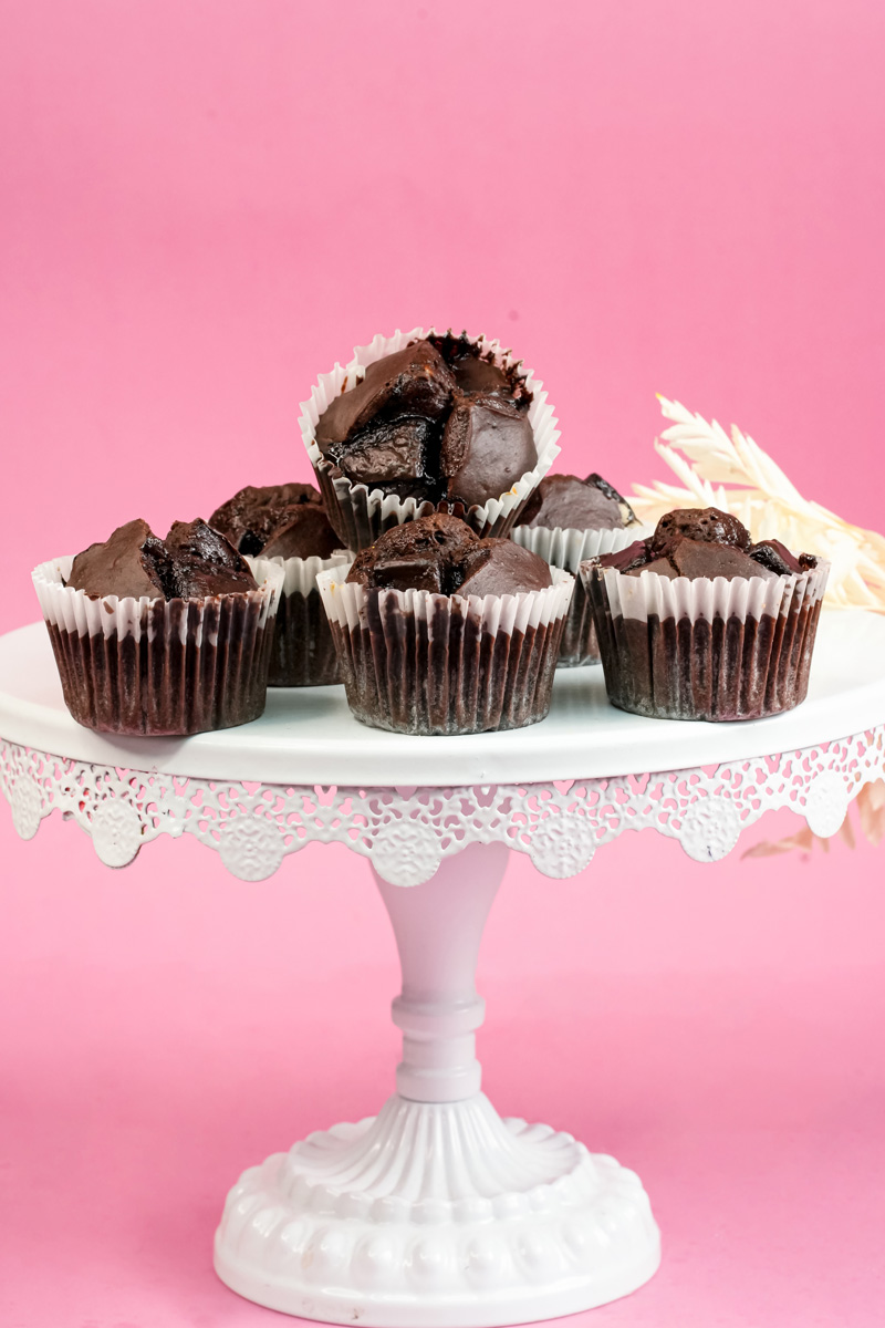 Dark peanut butter banana muffins displayed on decorative stand