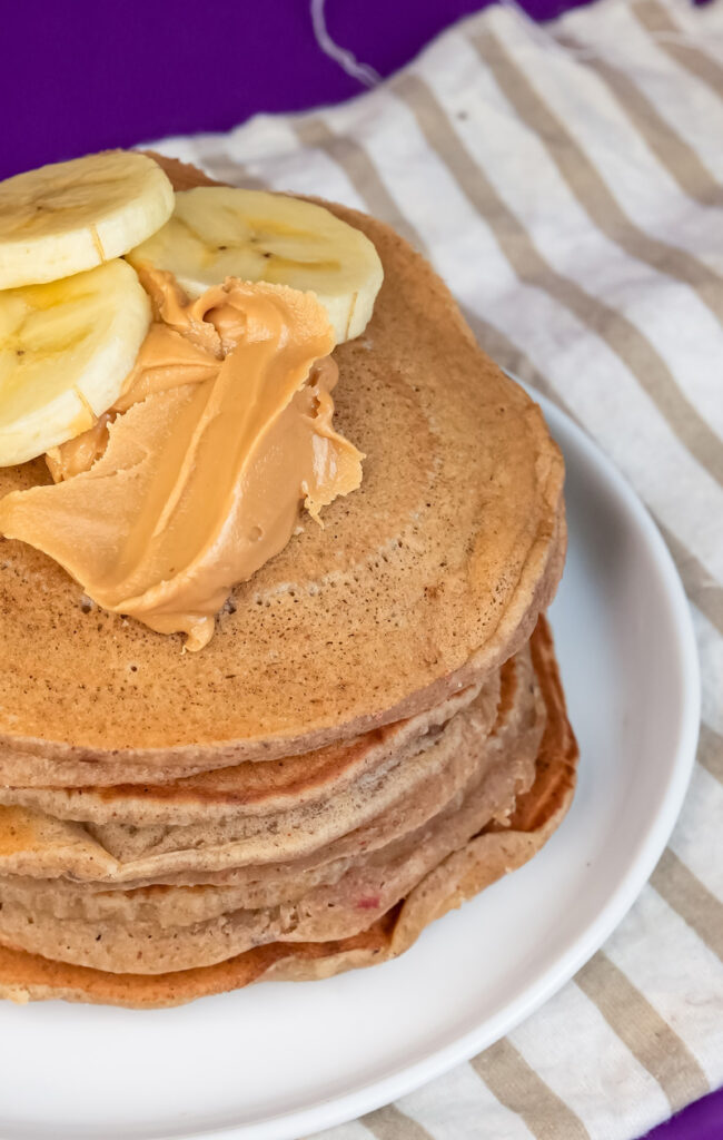 Delicious peanut butter pancakes with sliced bananas and creamy peanut butter