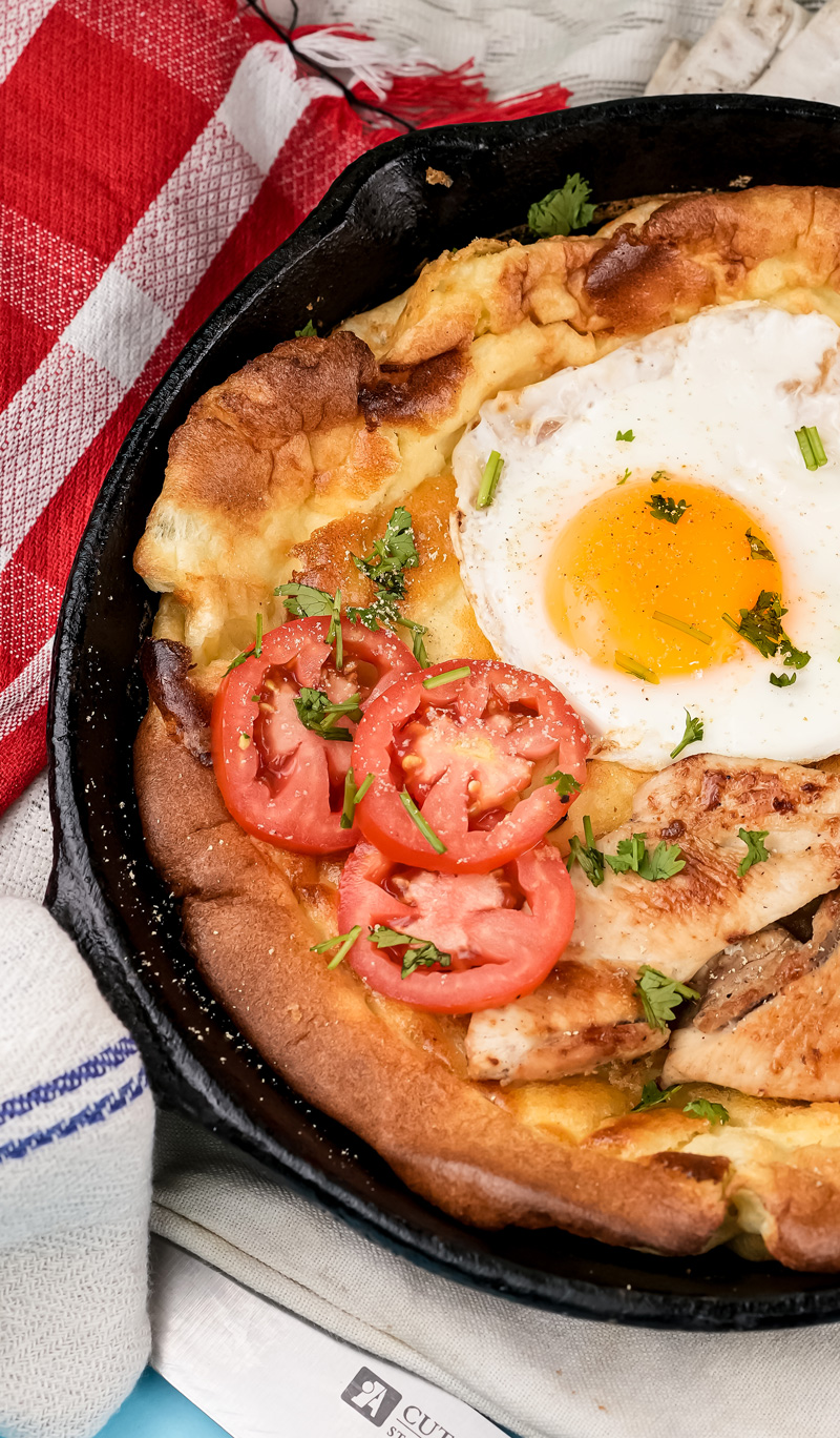 Close-up of Dutch baby pancake with fried egg and chicken